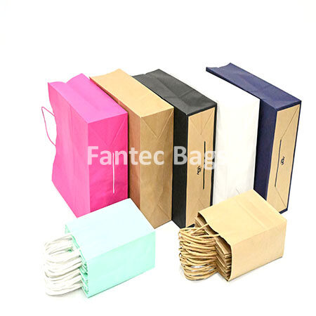 "Eco-friendly kraft paper shopping bags in multiple colors and sizes with twisted handles."