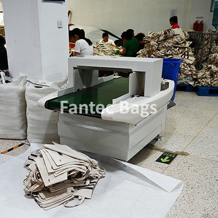 "Industrial pin detection machine inspecting cotton tote bags for quality control in a textile factory."