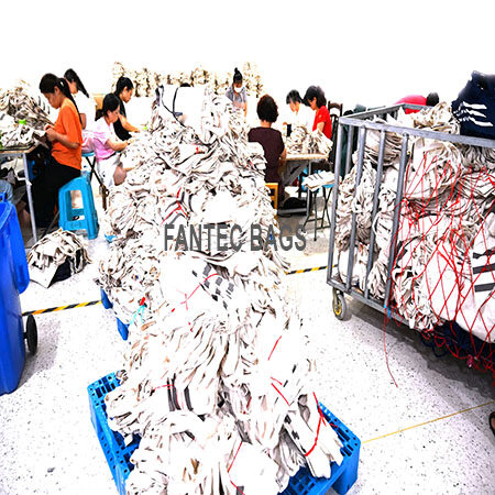 "Factory workers organizing cotton tote bags in stacks and carts, preparing them for shipment."
