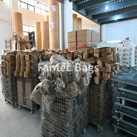 "Warehouse storage area with wire containers filled with kraft paper bags wrapped for shipment."
