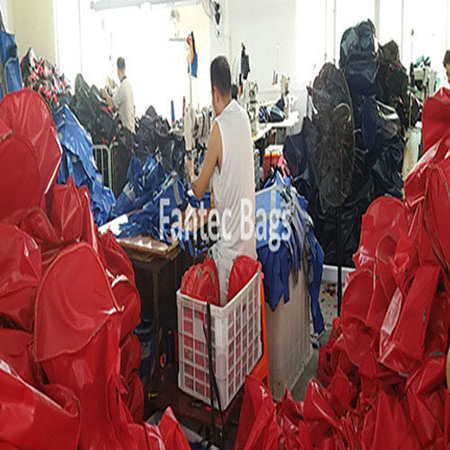 "Industrial sewing machine stitching edges of PVC and fabric bags for durability."