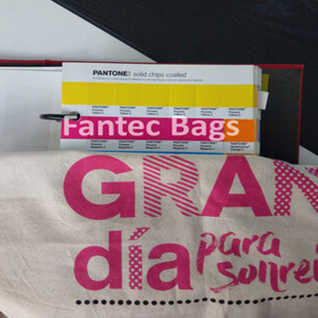 "Reference chart with printed letters inspected on cotton tote bag pattern for accuracy."