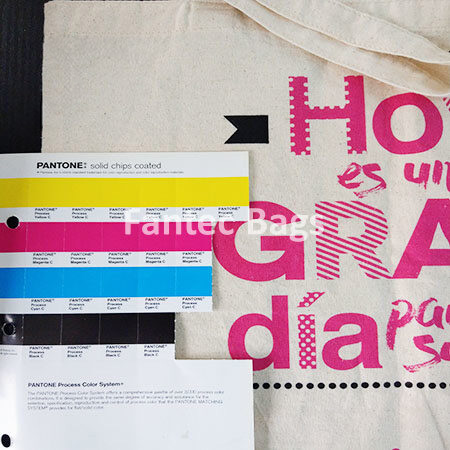 "Reference chart with Pantone compared against cotton tote bag print for shade verification."