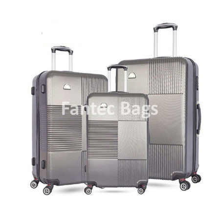 Three metallic gray suitcases with geometric textured design and spinner wheels